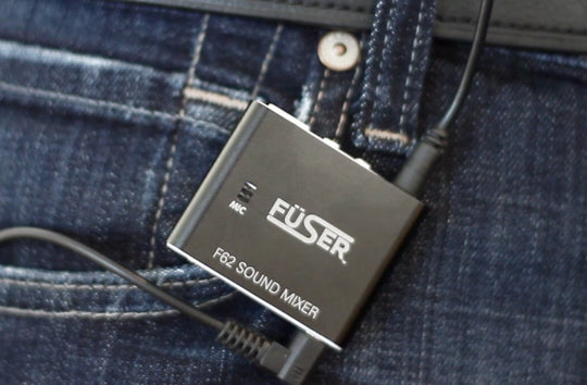 Clip-on FÜSER F2 sound mixer on blue denim with connected cable
