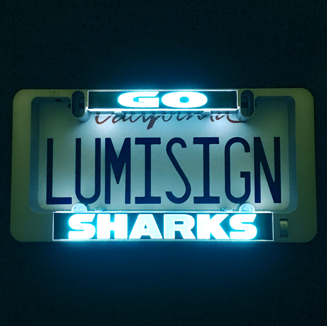 Gray LumiSign illuminated license plate frame with glowing LUMISIGN SHARKS text