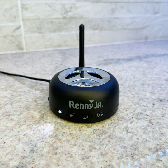 Loud cell phone ringer with vertical antenna and top speaker dial, on tabletop