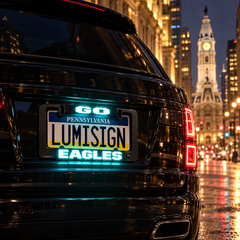 Black license plate frame with glowing LUMISIGN Eagles insert